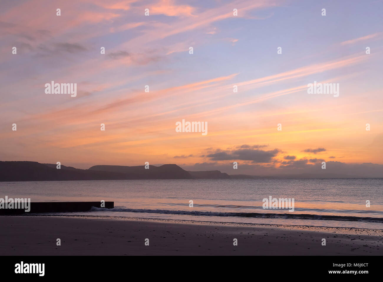 Sunrise in Lyme Regis guardando oltre verso il Golden Cap e la Jurassic Coast Foto Stock