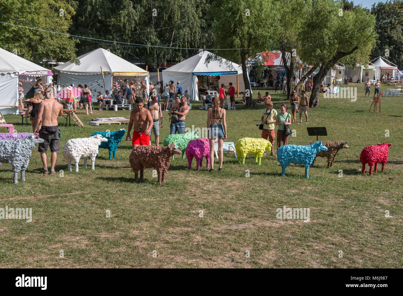 La gente guarda le illustrazioni di pecora al Sziget Festival a Budapest, Ungheria Foto Stock