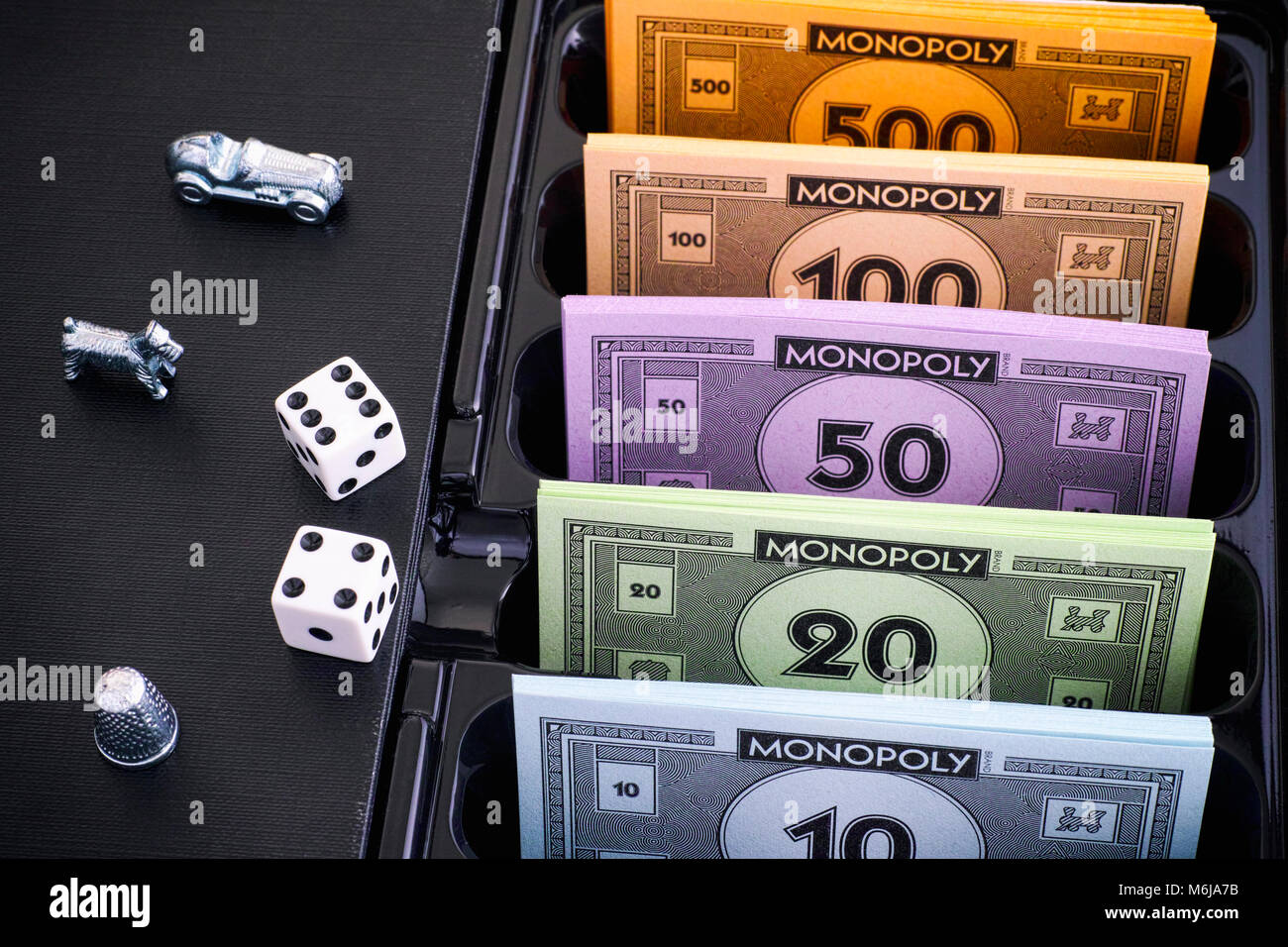 Tambov, Federazione Russa - 26 gennaio 2018 monopolio Board Game Box con pacchi di denaro, token e dadi. Foto Stock