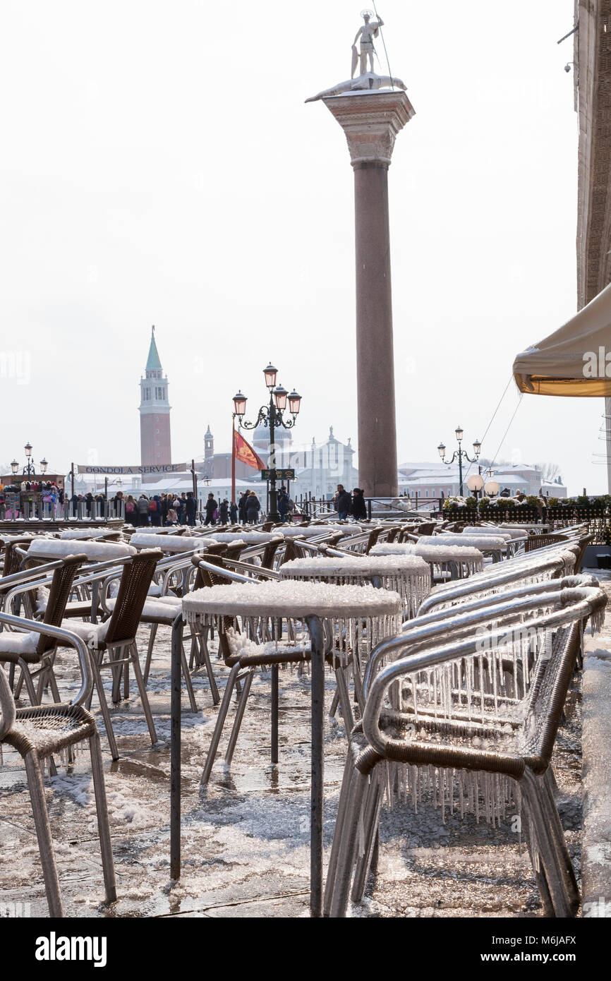 In inverno la neve e il ghiaccio, Piazza San Marco, Venezia, Veneto, Italia con rivestimento di ghiaccioli i tavoli e le sedie di fronte al Caffe Chioggia durante il Siberiano Foto Stock