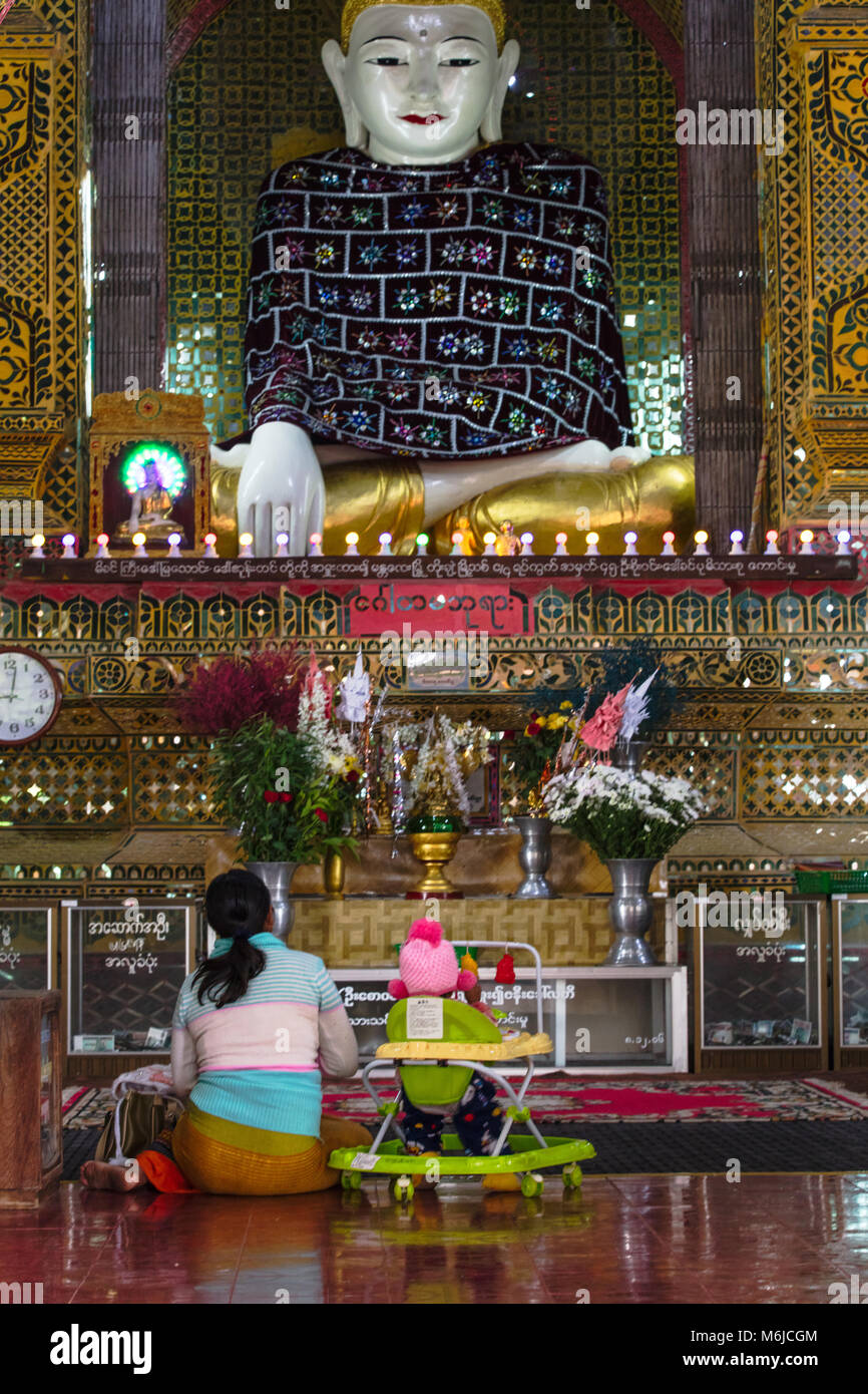 Popolo birmano in preghiera di fronte al Buddha all'interno della Pagoda Sutaungpyei. Mandalay Hill, Myanmar (Birmania). Foto Stock