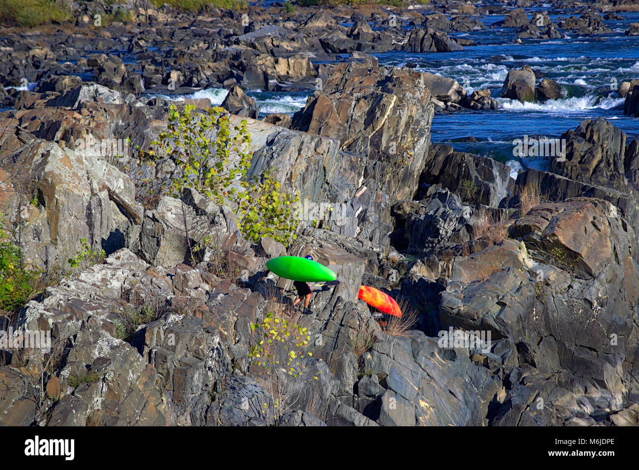 Gli uomini tenendo i loro kayak torna in alto di rapide Foto Stock