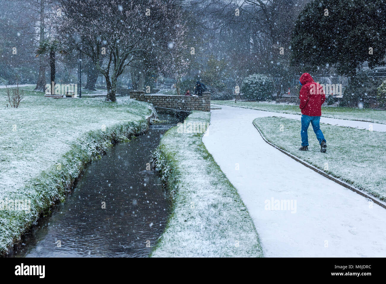 Persone che camminano attraverso forti nevicate nei Trenance Gardens a Newquay in Cornovaglia nel Regno Unito. Foto Stock
