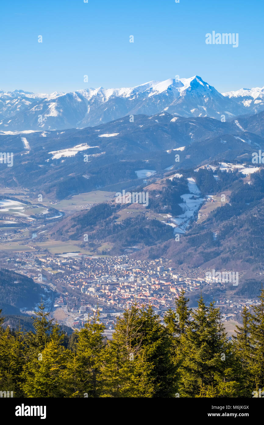 Vista aerea dalla montagna Rennfeld a valle Muerztal con città di Bruck an der Mur e distante montagna innevata top Goesseck in inverno Foto Stock