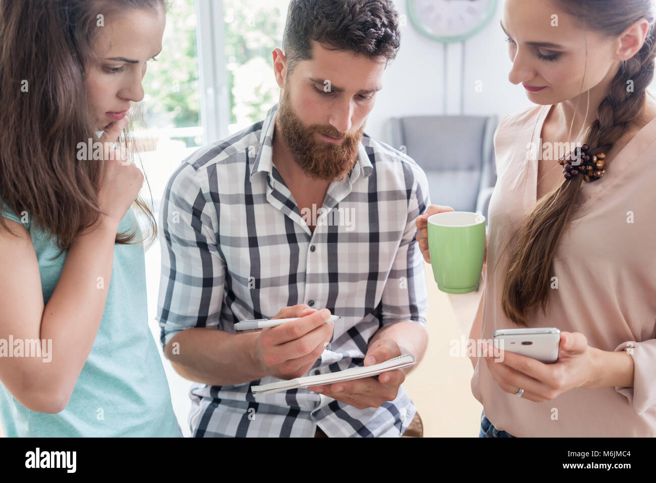 Tre collaboratori durante una sessione di brainstorming Foto Stock