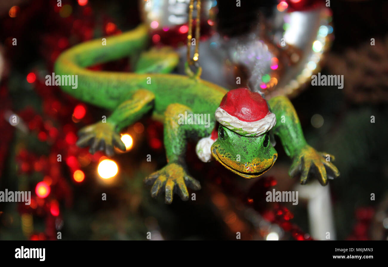 Il geco con Santa hat ornamento di Natale con albero sfocate con luci in background - messa a fuoco selettiva. Foto Stock