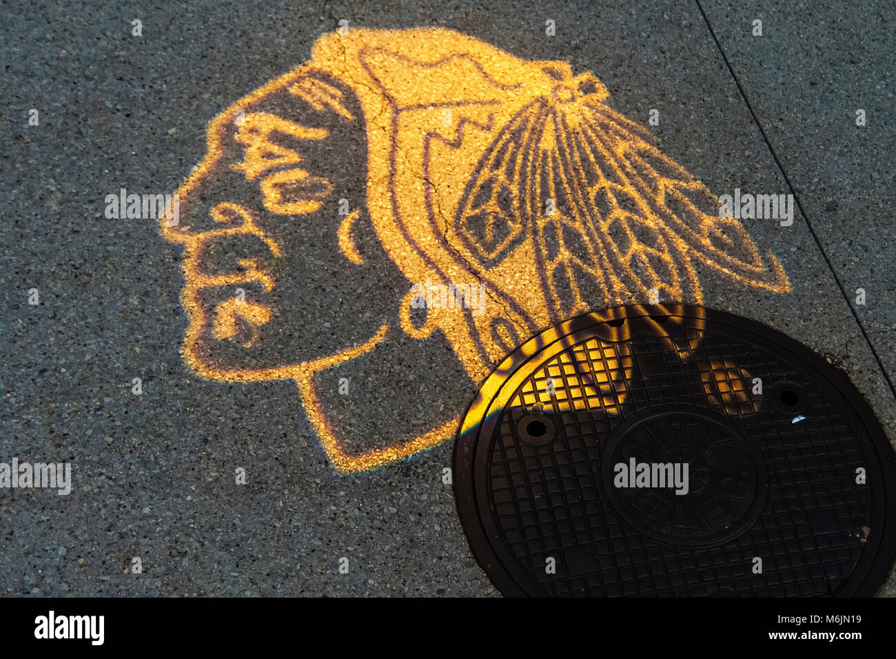 Il logo del Chicago squadra di hockey il BlackHawks proiettata su un marciapiede dietro il negozio BlackHawks nel distretto di Loop, Chicago, Illinois. Foto Stock