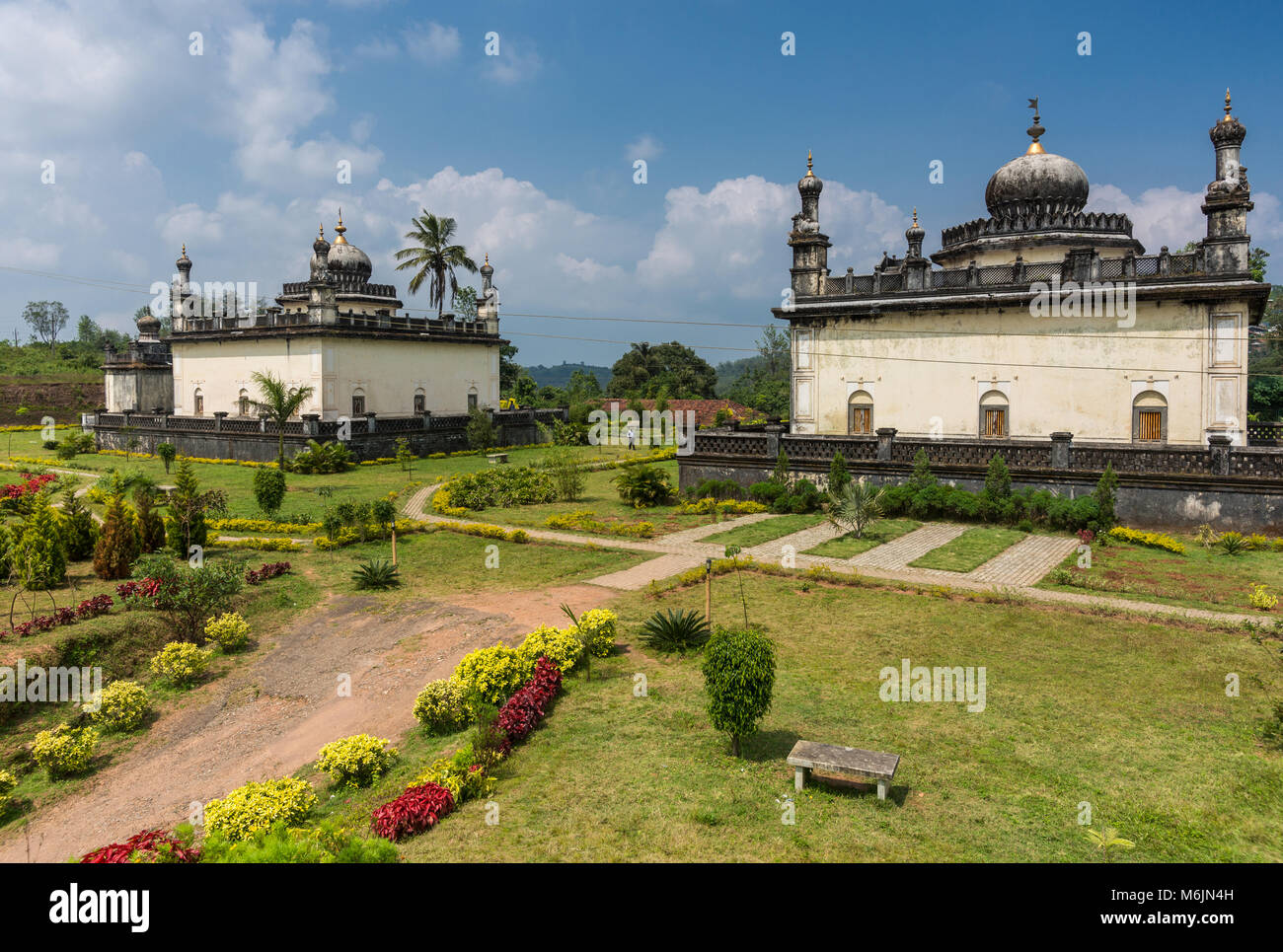 Madikeri, India - 31 Ottobre 2013: tre maggiori di bianco e grigio mausoleo reale immerso nel verde giardino del dominio Raja tombe sotto il cielo blu con nuvole. Foto Stock