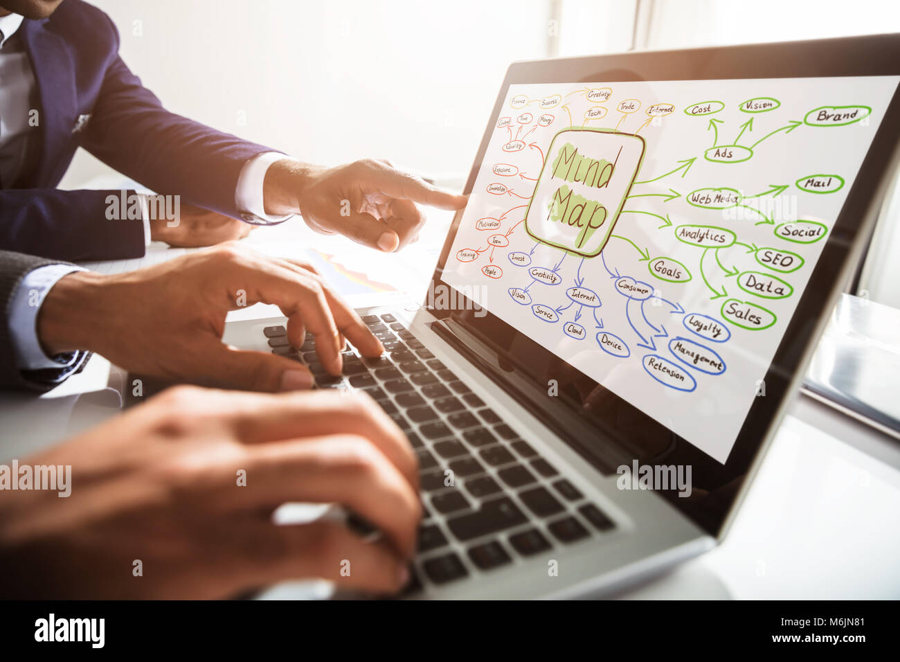 Close-up di due imprenditori rendendo mappa mentale su laptop al lavoro Foto Stock