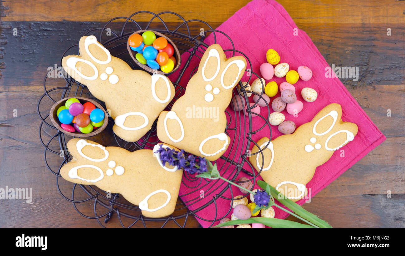 Felice Pasqua il sovraccarico con Easter Bunny cookies e decorazioni su una tavola di legno di sfondo Foto Stock