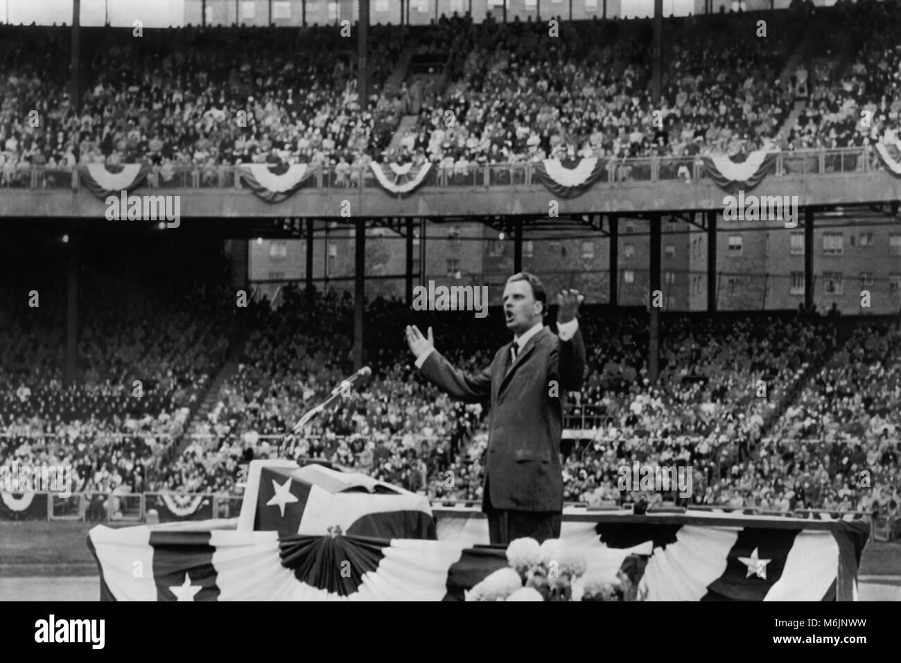 Billy Graham (1918-2018) la predicazione a 40.000 persone il 27 ottobre 1957 presso la riforma annuale Giornata di servizio tenuto presso il Polo motivi in New York City. Foto Stock