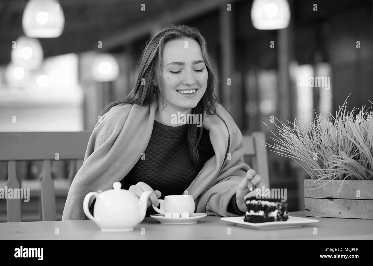 Ragazza in un cafe seduta e di bere il tè Foto Stock