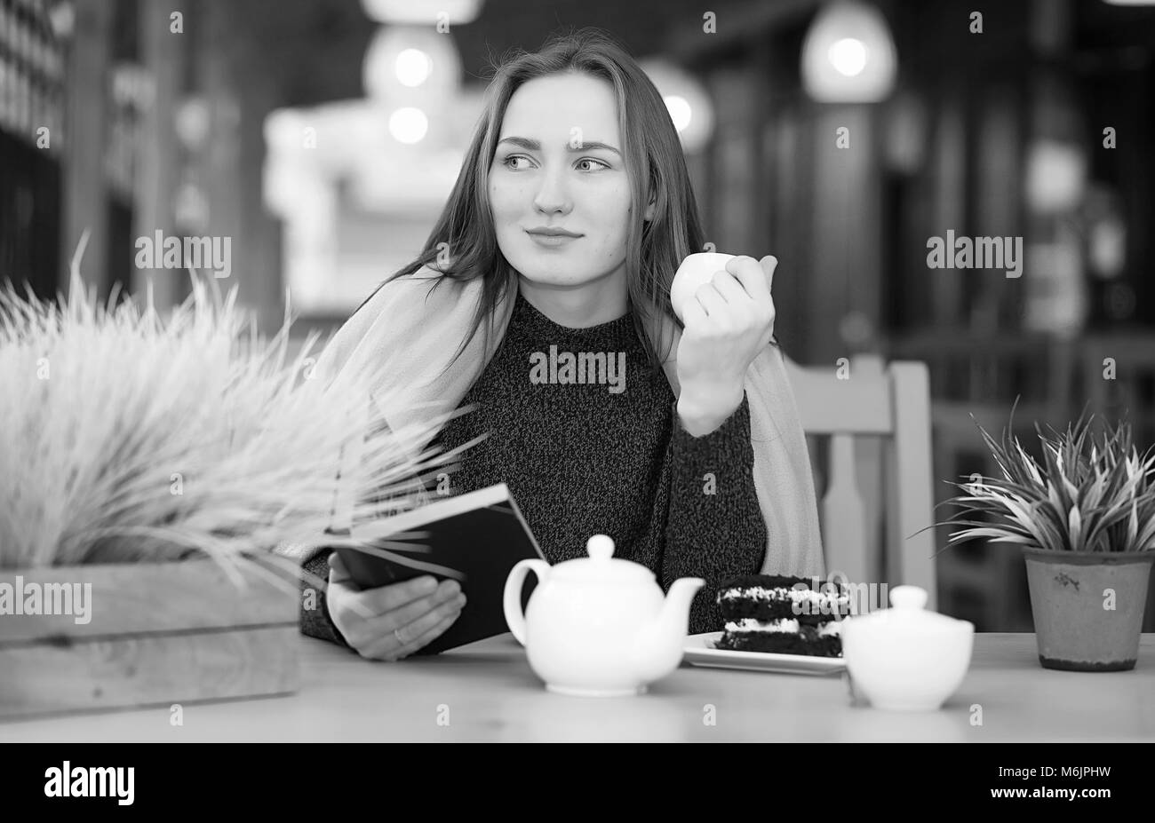 Ragazza in un cafe seduta e di bere il tè Foto Stock