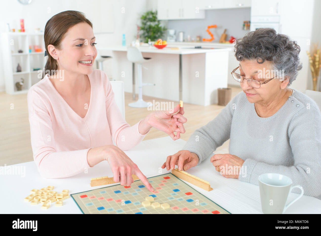 Un gioco di Scrabble con una vecchia donna Foto Stock