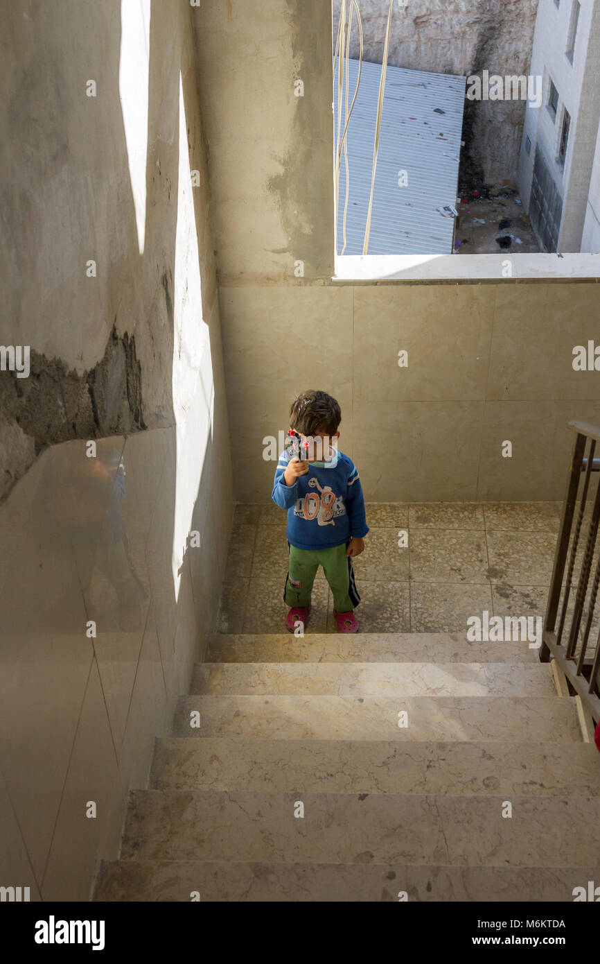 Gerusalemme, Israele, 2 Novembre 2010: palestinese bambino gioca sulla scala di un blocco. La povertà nel camp è diffusa, è tagliata fuori dal resto o Foto Stock