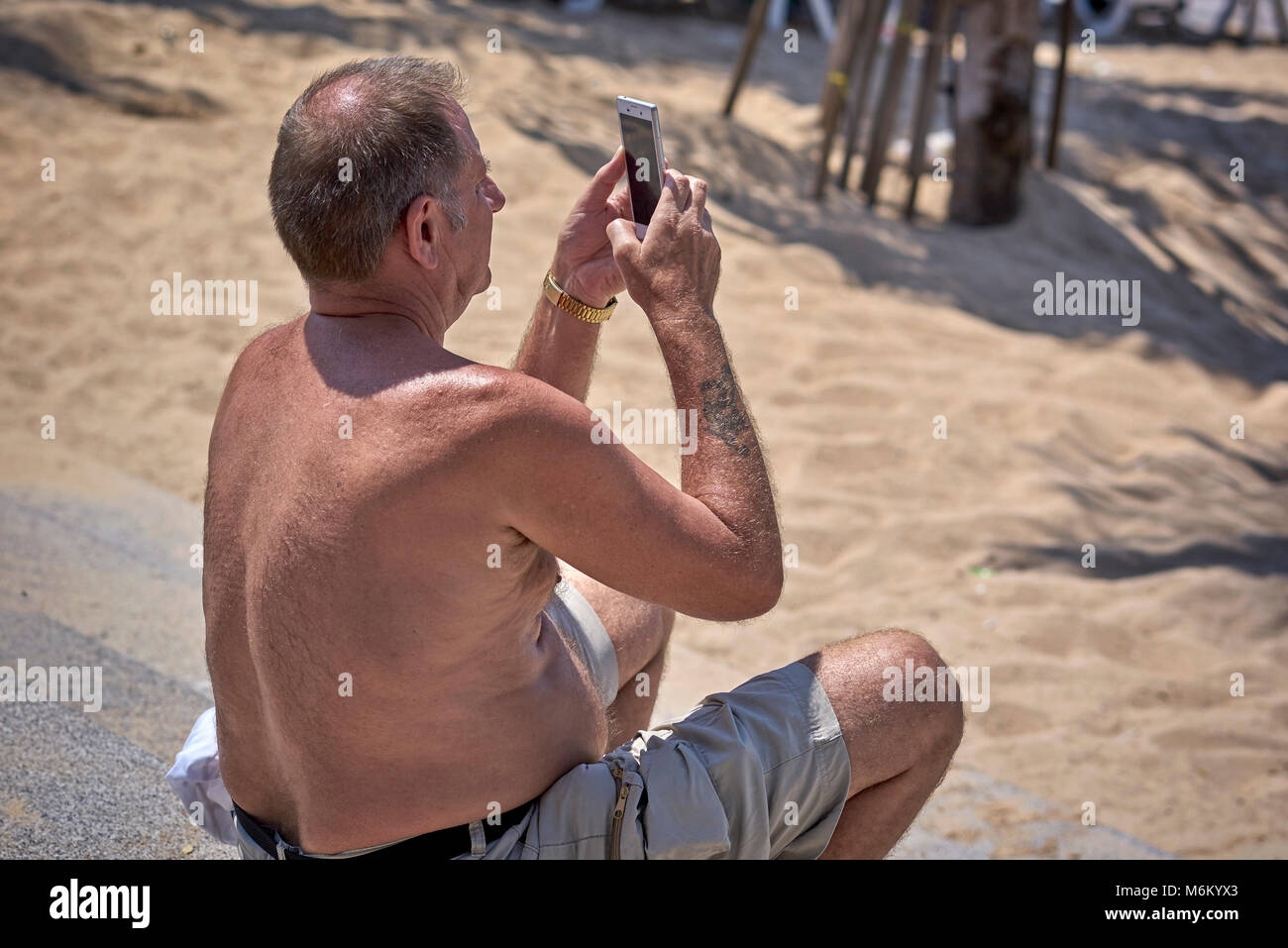 Uomo che usa lo smartphone per scattare una fotografia Foto Stock