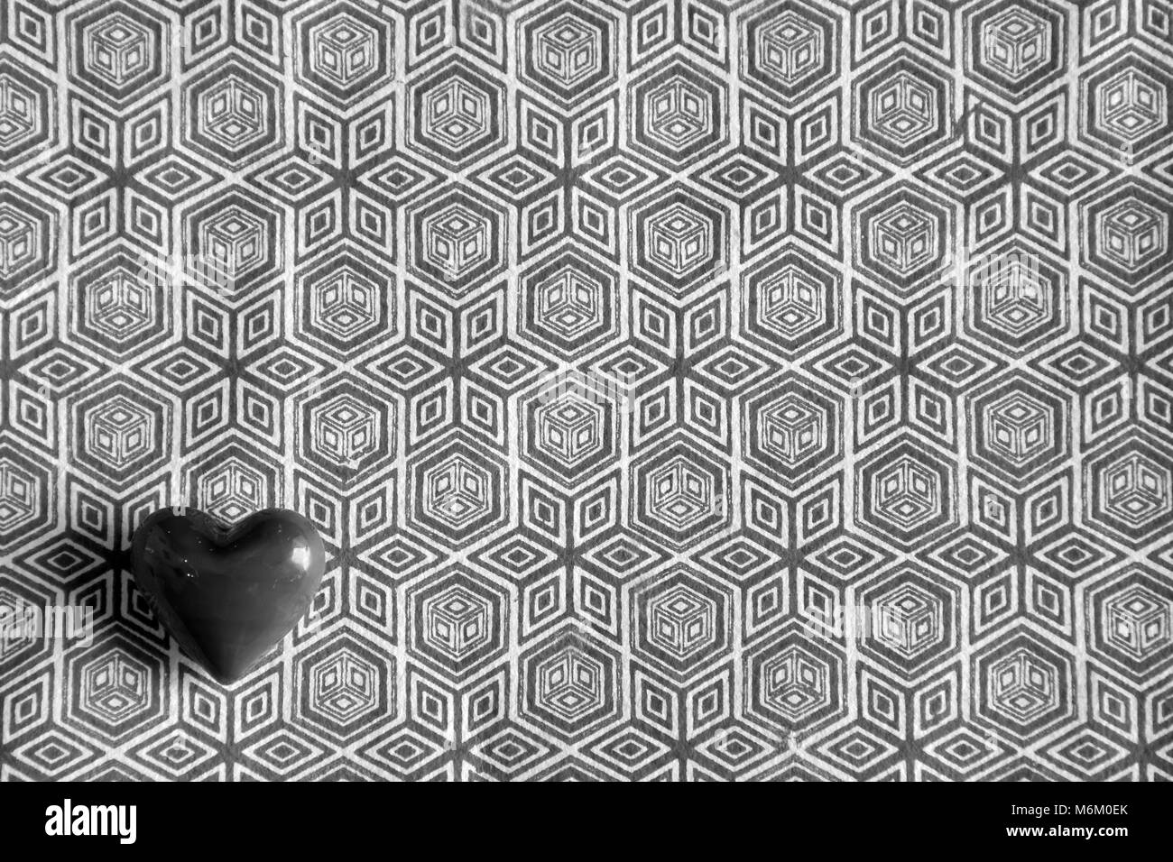 Piccolo rosso amore cuore ciottoli contro uno sfondo semplice Foto Stock