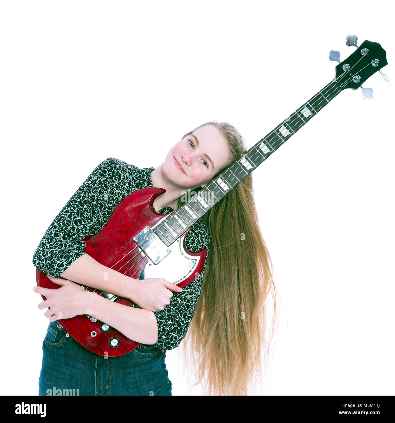 Blonde teen girl e bass guitar contro uno sfondo bianco in studio Foto Stock