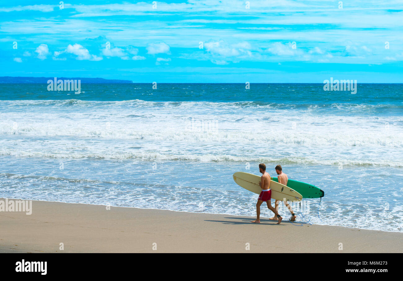 CANGGU, isola di Bali, Indonesia - Jan 19, 2017: Surfers a piedi con la tavola da surf in spiaggia. Isola di Bali è una delle migliori destinazioni di navigazione Foto Stock
