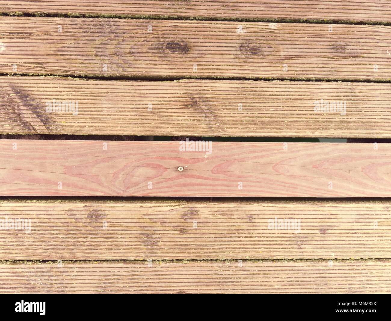 Il davanzale bagnato in legno duro con scheda resiste agli agenti atmosferici la superficie. Pavimento in legno di spiaggia pier, doghe del pavimento al di sopra di mare Foto Stock