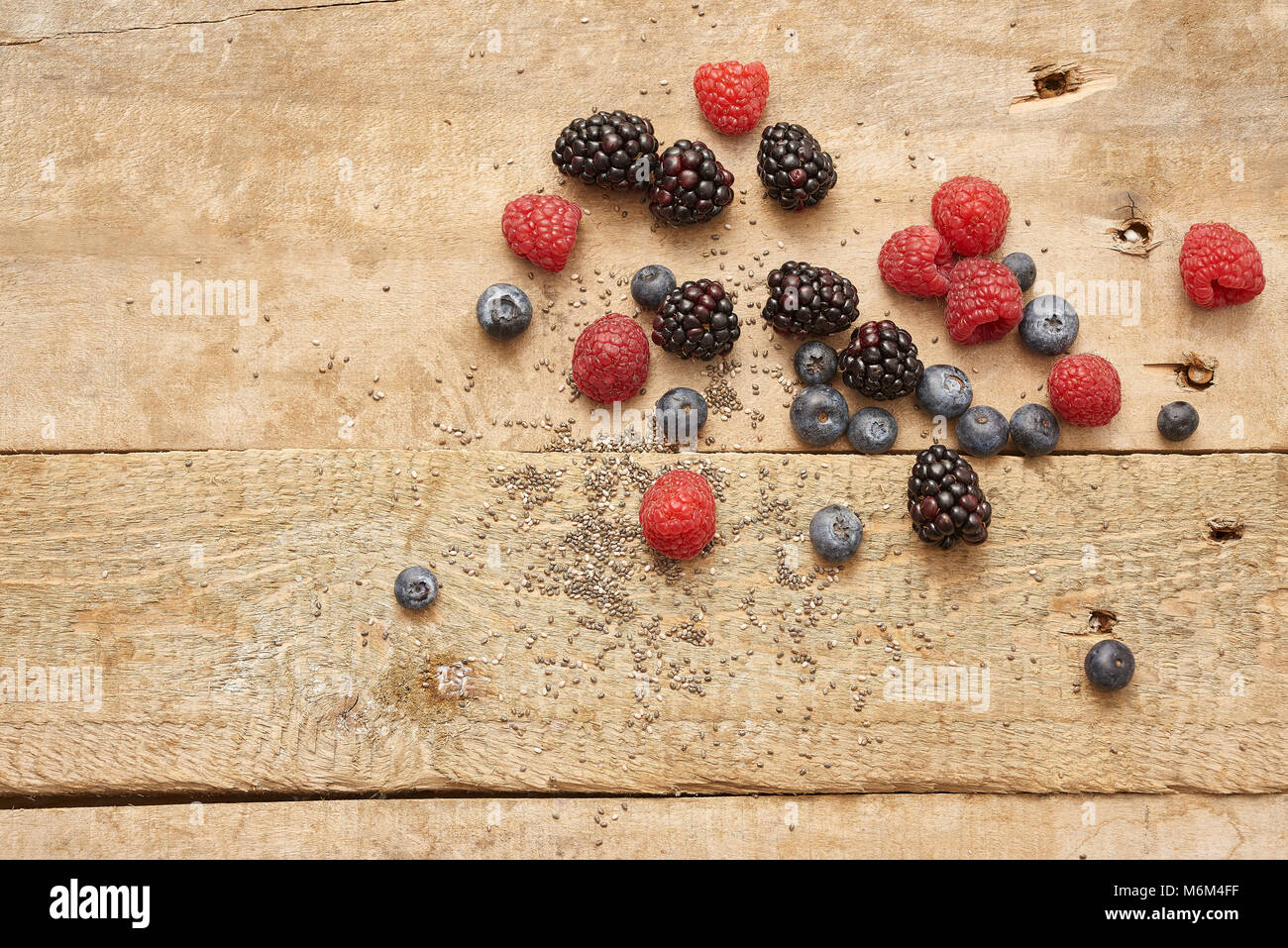 Diverse bacche fresche sul rustico sfondo di legno Foto Stock