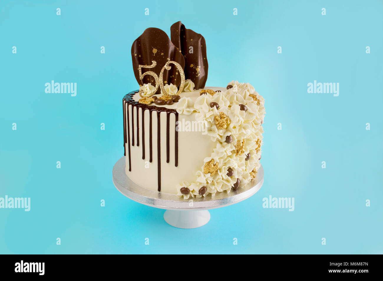 Cinquantesimo compleanno celebrazione volant torta antigoccia,cioccolato Belga, antigoccia vele al cioccolato e caffè noce sul blu turchese sfondo verde Foto Stock
