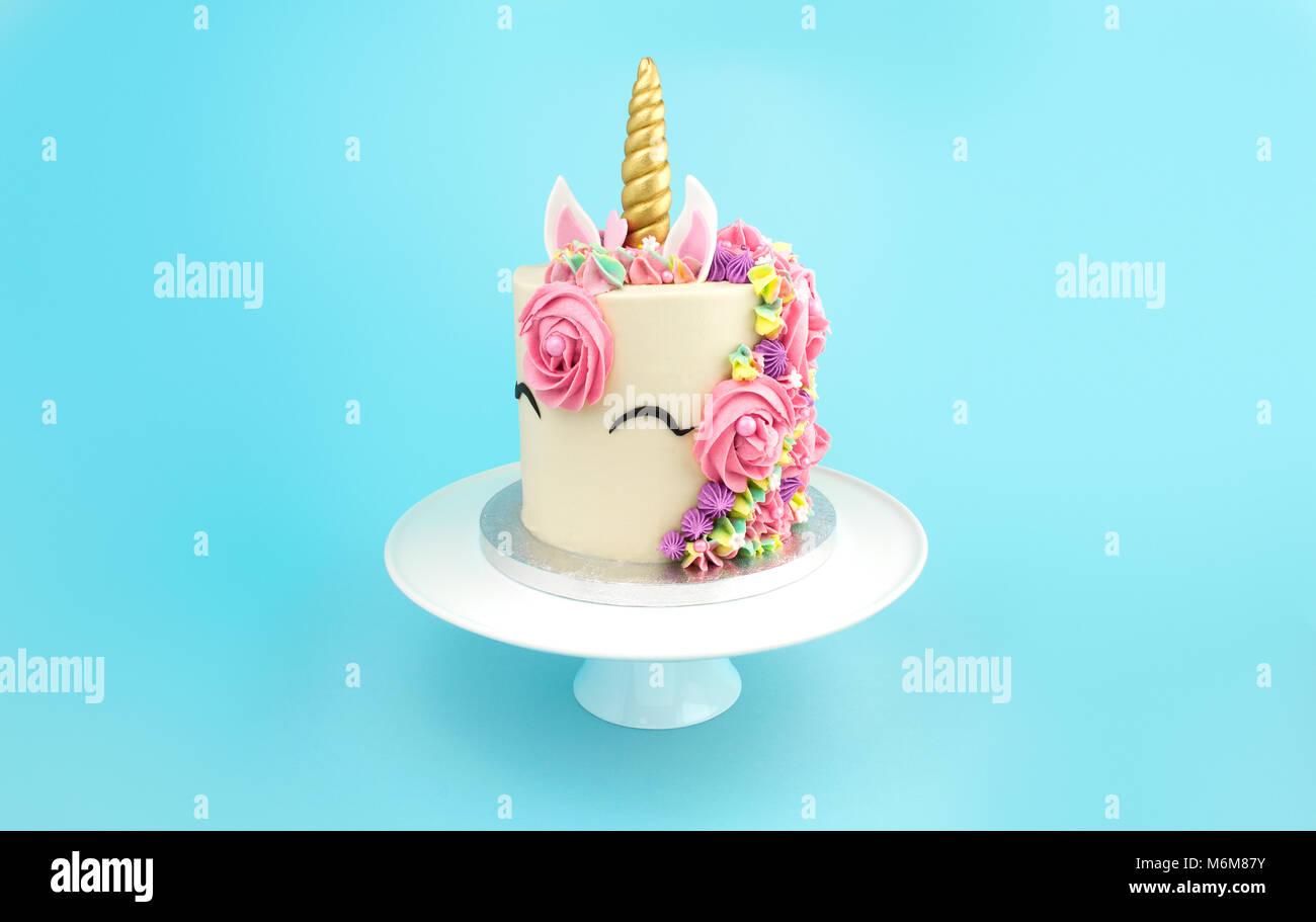 Unicorn Torta di crema di burro sulla torta bianca stand su sfondo turchese Foto Stock