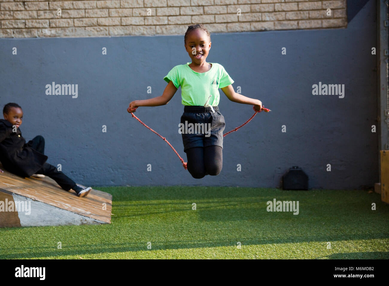 Bambino saltando su una corda da salto Foto Stock