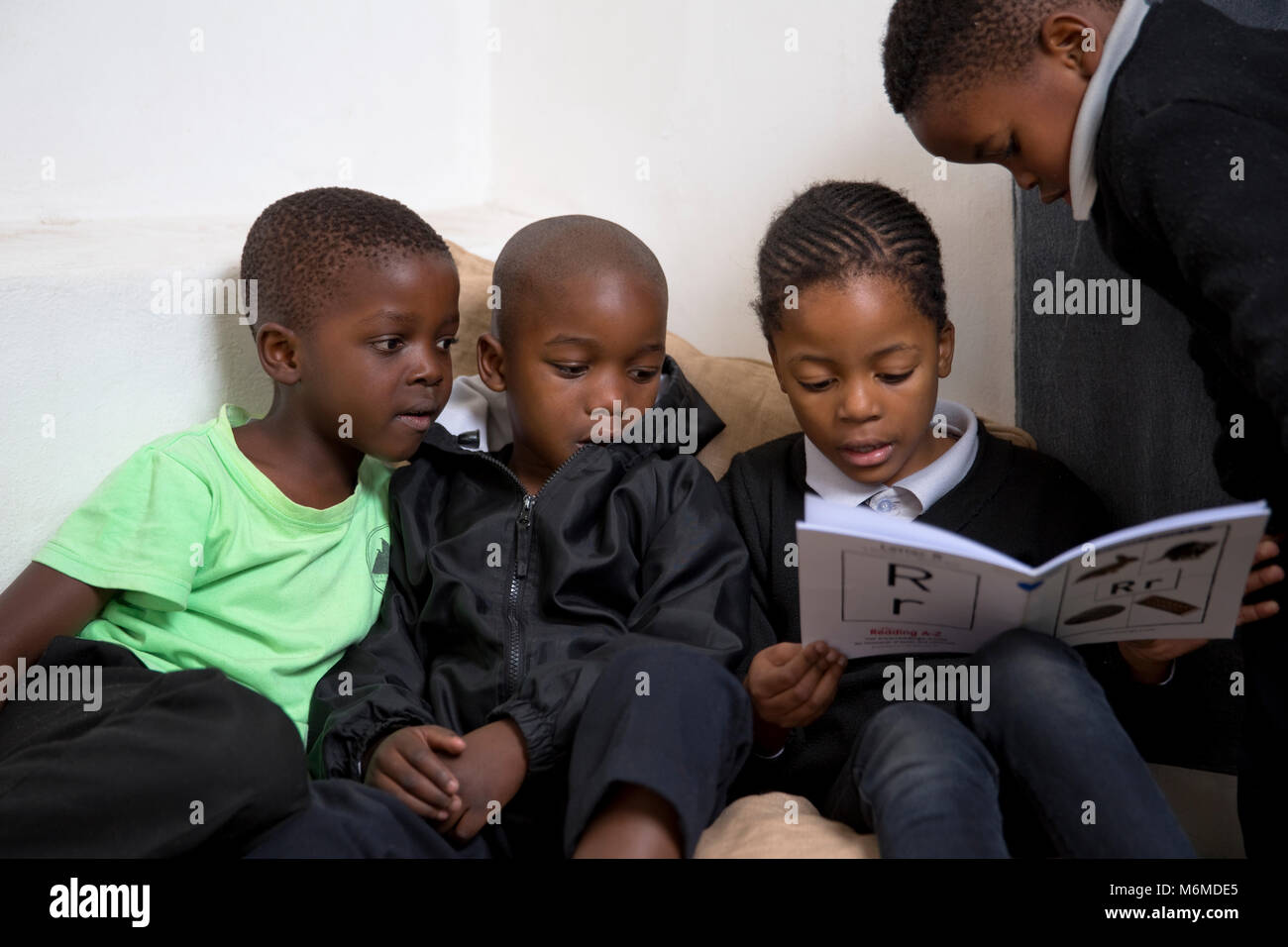 I bambini della scuola lettura in classe Foto Stock
