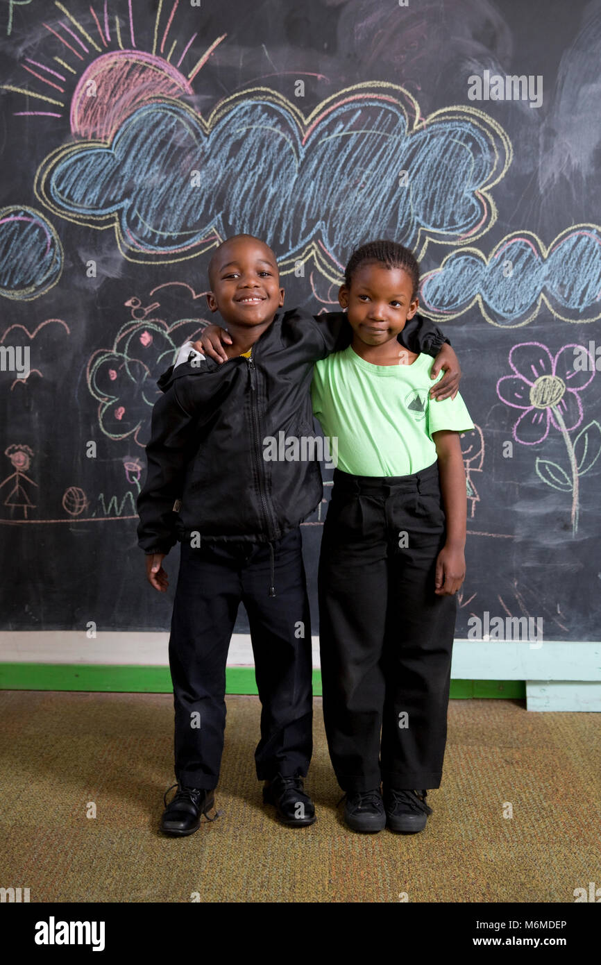 Ritratto di due giovani bambini che pongono in classe Foto Stock