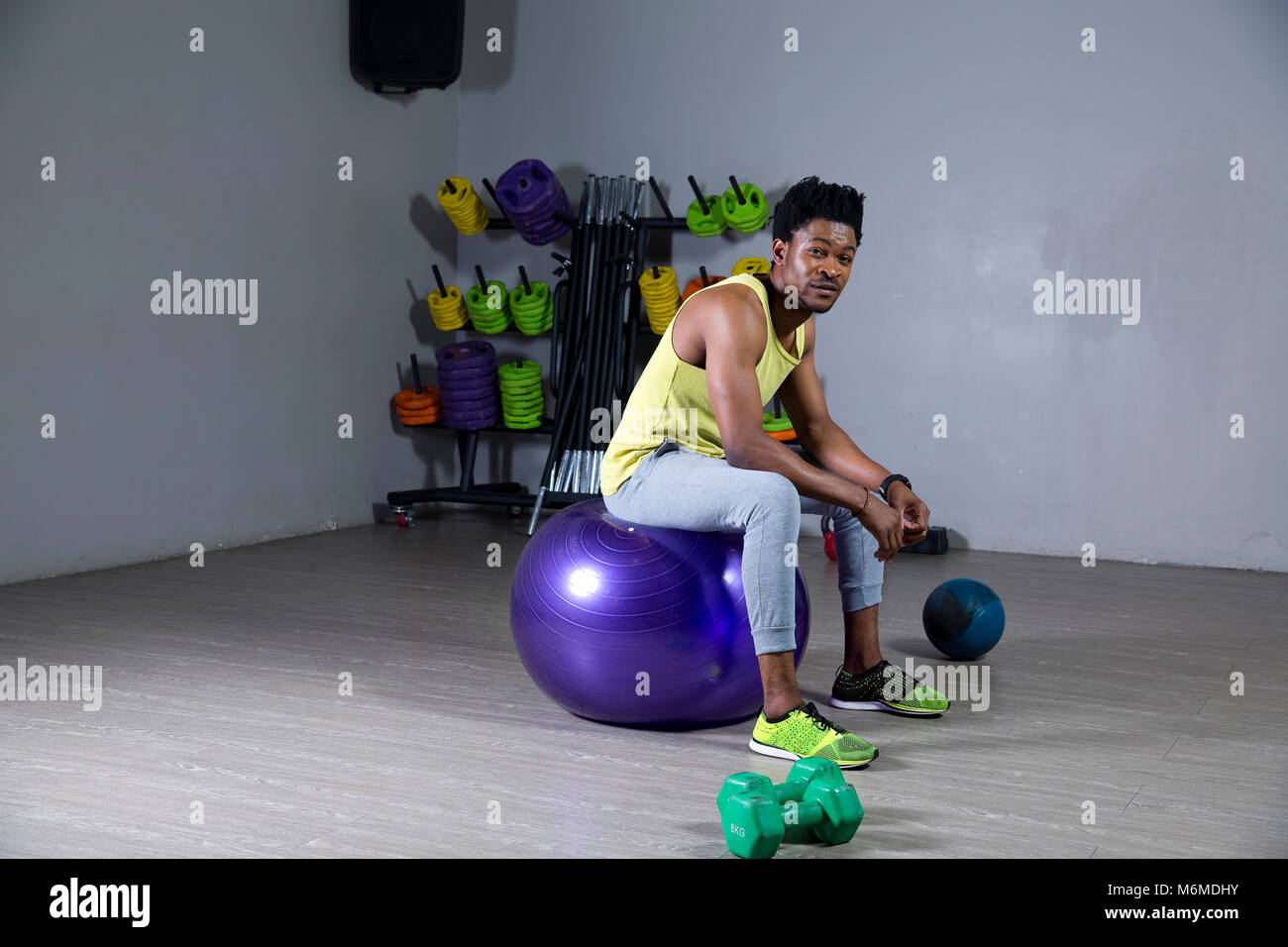 African uomo seduto su una palla ginnica Foto Stock