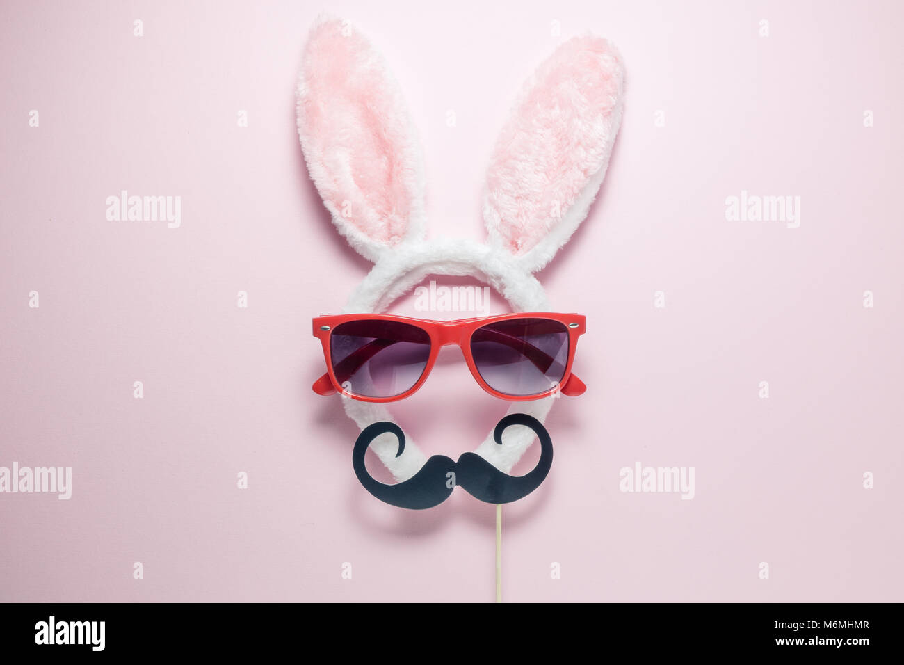 Appartamento stabilire la minima nozione di astratta bunny con occhiali da sole e baffi sulla pianura pastello sfondo rosa Foto Stock