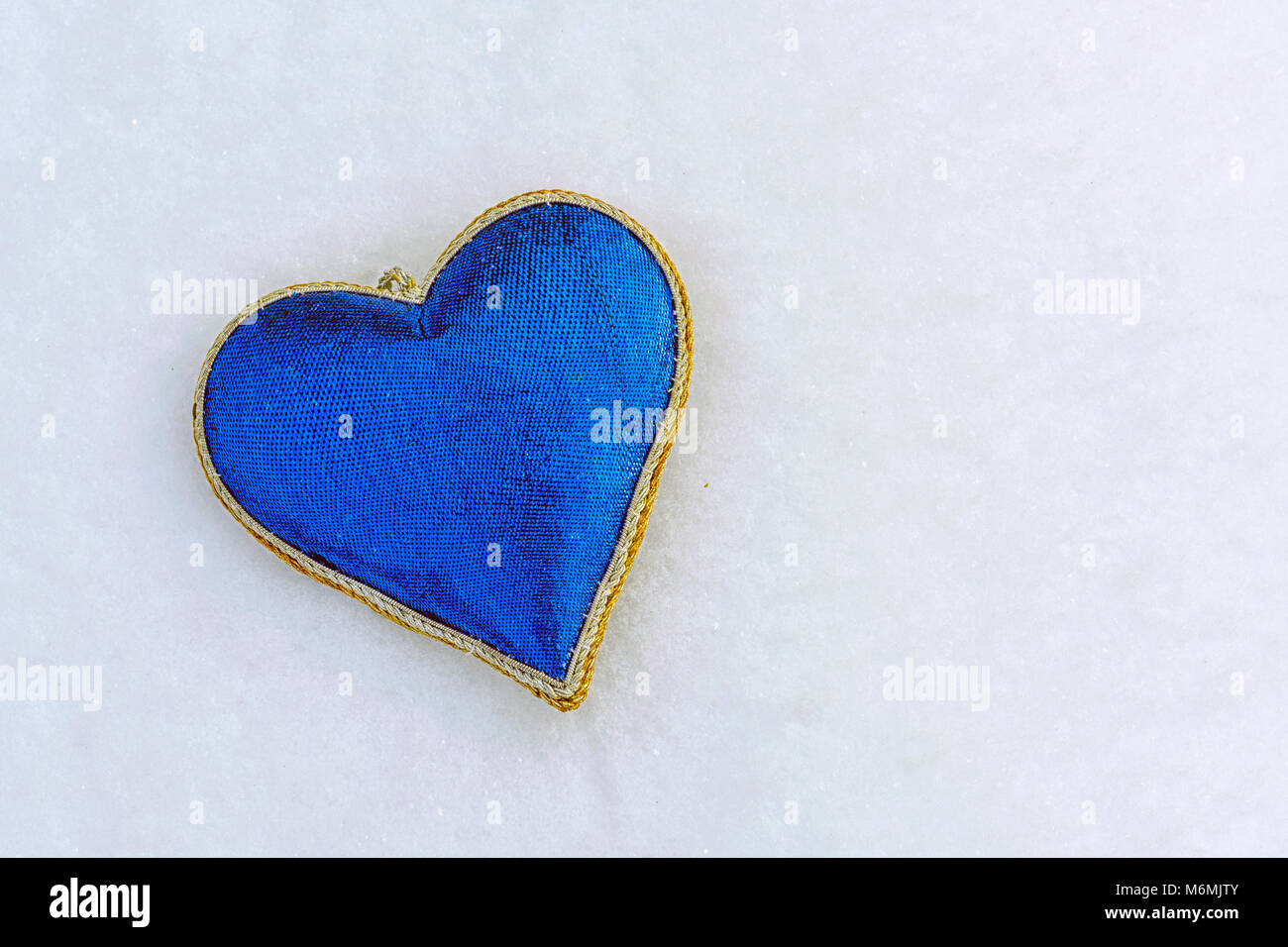 La forma di un cuore blu sulla neve in inverno, 14 Febbraio è il giorno di San Valentino Foto Stock