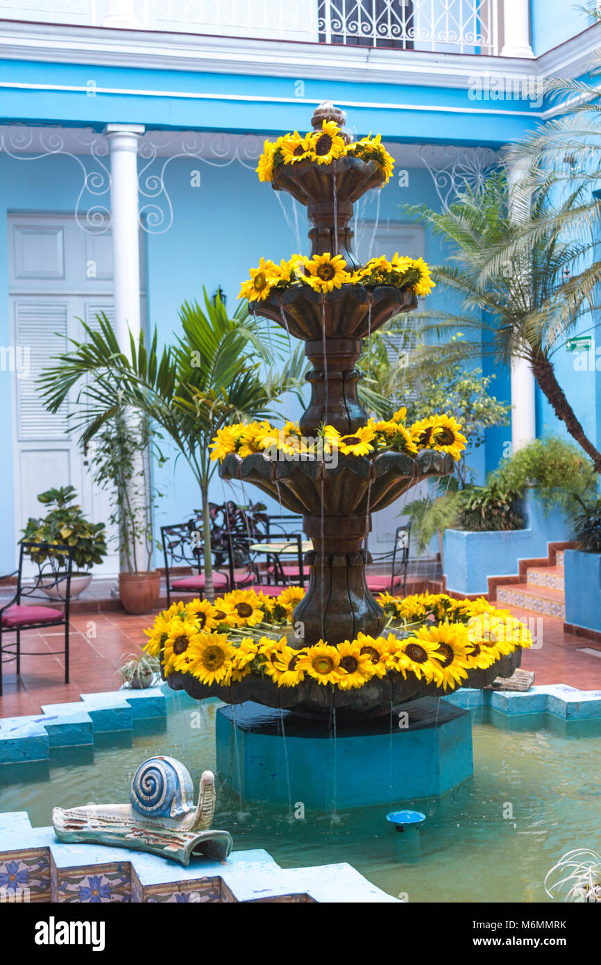 Fontana in blu cortile interno della Union Hotel decorato con girasoli Foto Stock