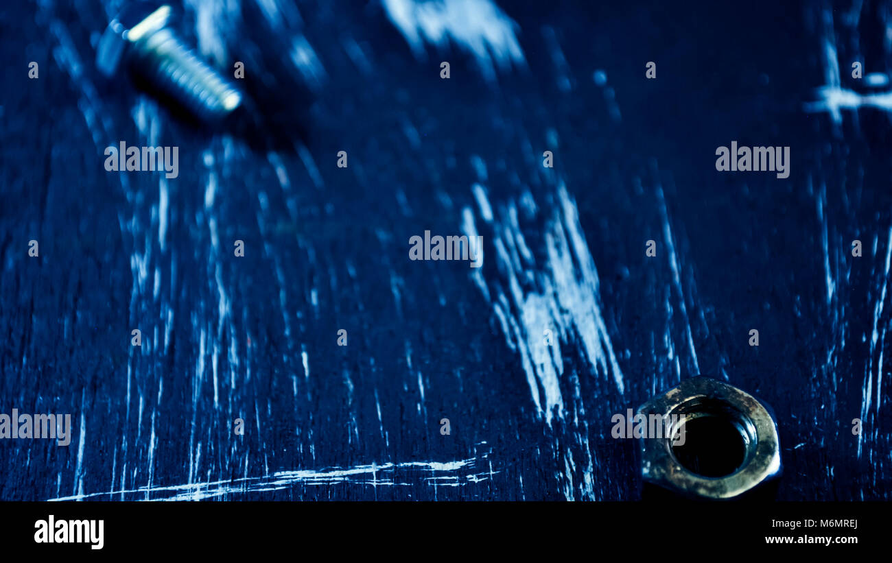 Dadi per le riparazioni che giace su di un tavolo di legno. I dadi di ferro e viti f Foto Stock