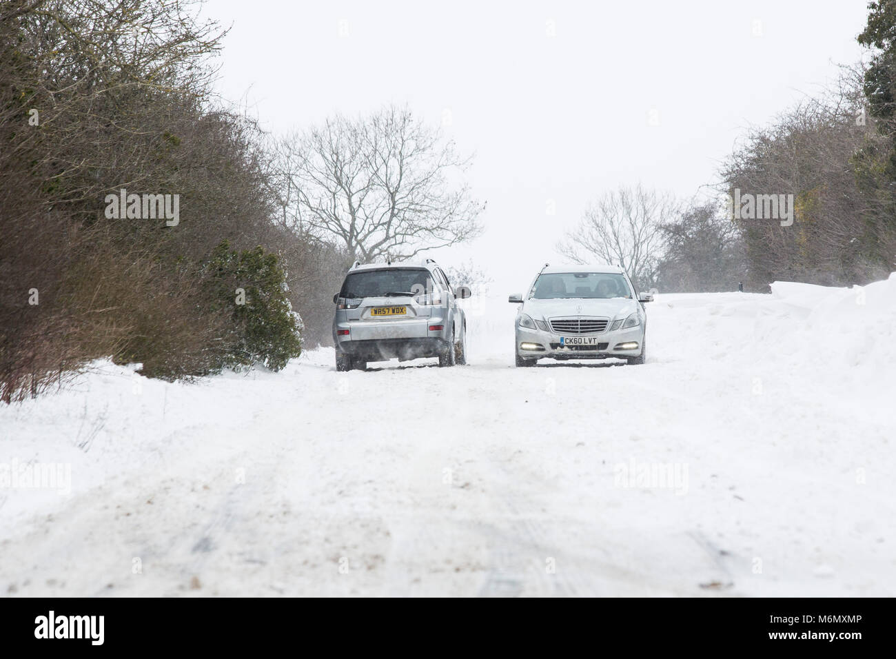 Gli automobilisti la bordatura attraverso le derive di neve e vento forte come il loro viaggio sulla strada Gloucestrer outsiode Cirencester NEL REGNO UNITO. Foto Stock