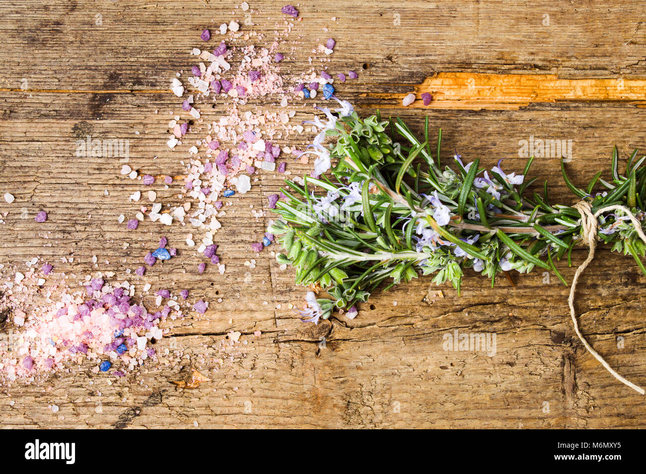 Bouquet di rosmarino e bagno alle erbe sale su una tavola di legno Foto Stock