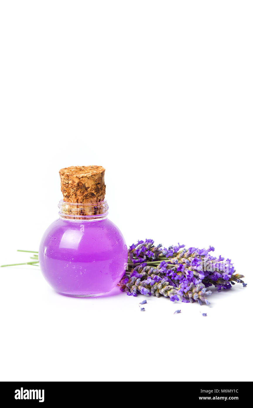 Olio di lavanda e bouquet di fiori isolati su bianco Foto Stock