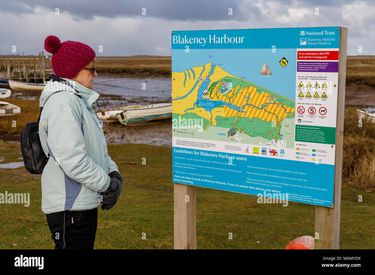 Rambler legge la bacheca a Morston Quay, parte del porto Blakeney la regione del nord litorale di Norfolk, Regno Unito. Foto Stock