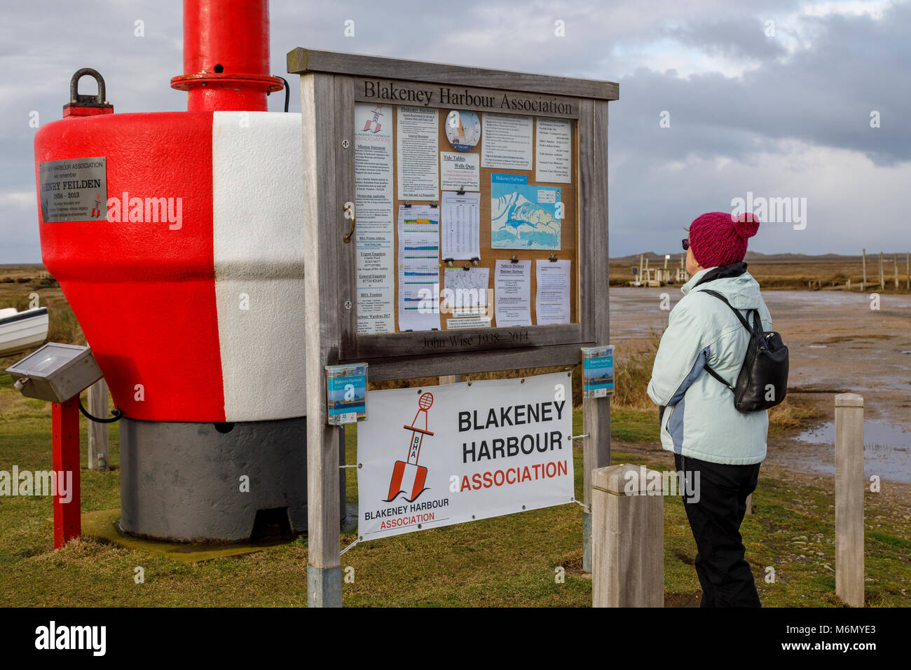 Rambler legge la bacheca a Morston Quay, parte del porto Blakeney la regione del nord litorale di Norfolk, Regno Unito. Foto Stock