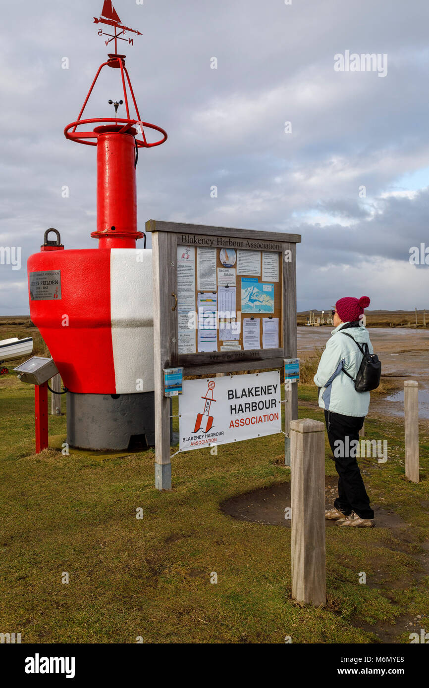 Rambler legge la bacheca a Morston Quay, parte del porto Blakeney la regione del nord litorale di Norfolk, Regno Unito. Foto Stock