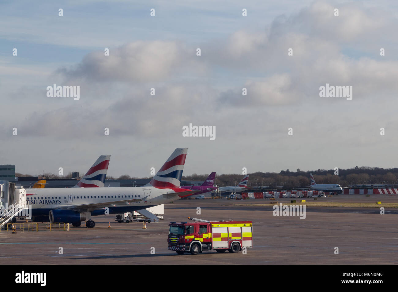 Un motore antincendio di fronte agli aerei della British Airways all'aeroporto di Gatwick, Londra, Regno Unito. Foto Stock