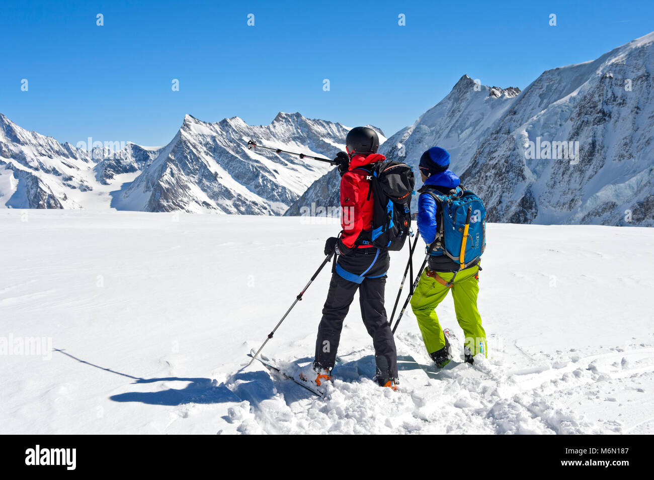 Due ski tourer guardando dal Loetschluecke passano attraverso le grosse Aletschfirn snowfield verso Konkordiaplatz e le Alpi Bernesi, Loetschental, Foto Stock