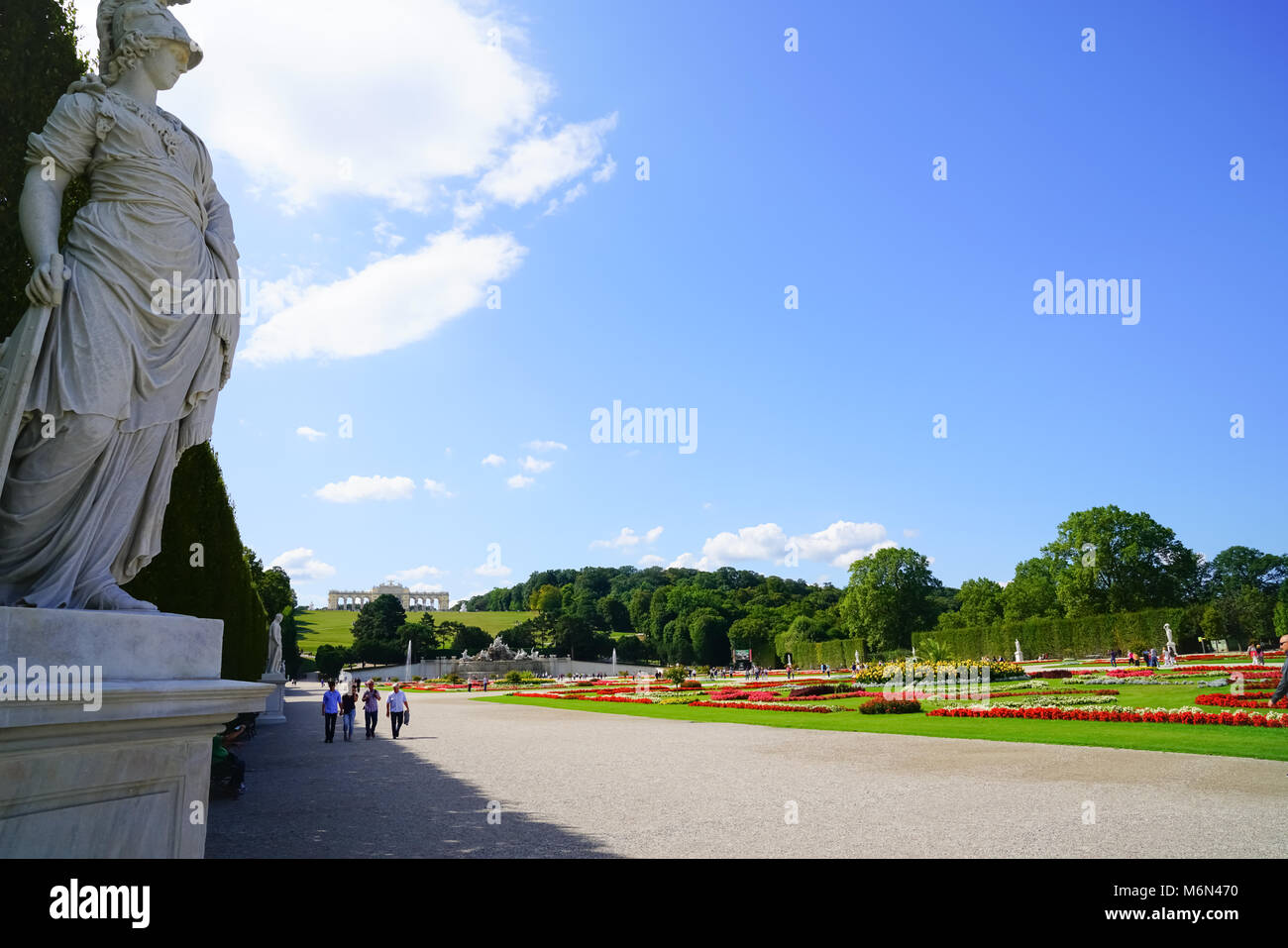 VIENNA, Austria - 4 settembre 2017; turisti in arrivo alla mattina a piedi sul lato ombroso passato per la cura di prati e giardini formali e statue di Schonbrunn imper Foto Stock