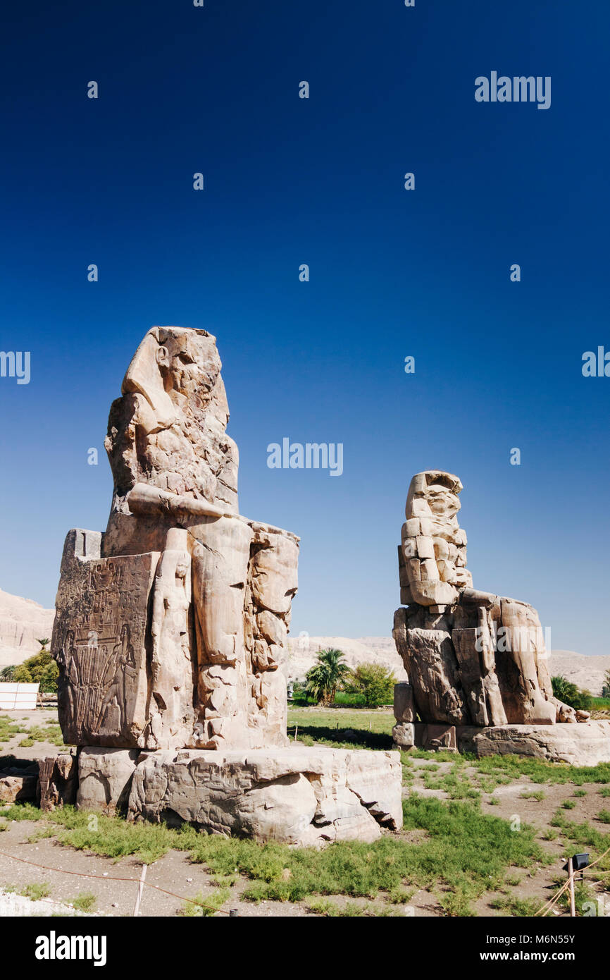 Luxor, Egitto. Colosso di Memnon, due enormi statue di pietra del faraone Amenhotep III, che regnò in Egitto durante la dinastia XVIII. Foto Stock