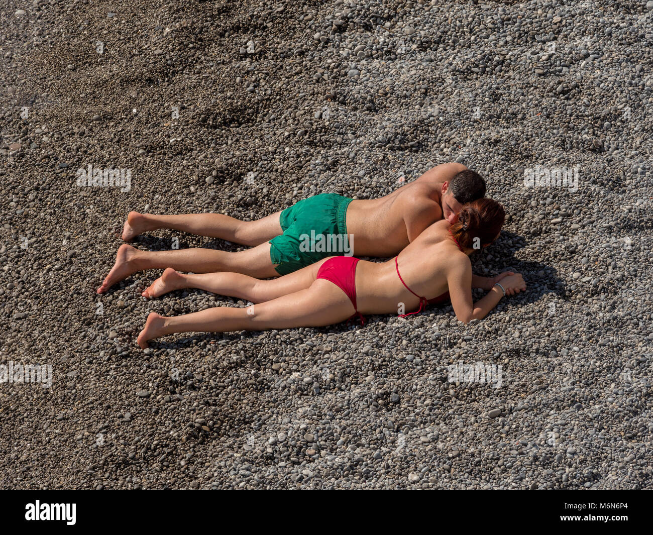 Coppia giovane a prendere il sole sulla spiaggia Foto Stock