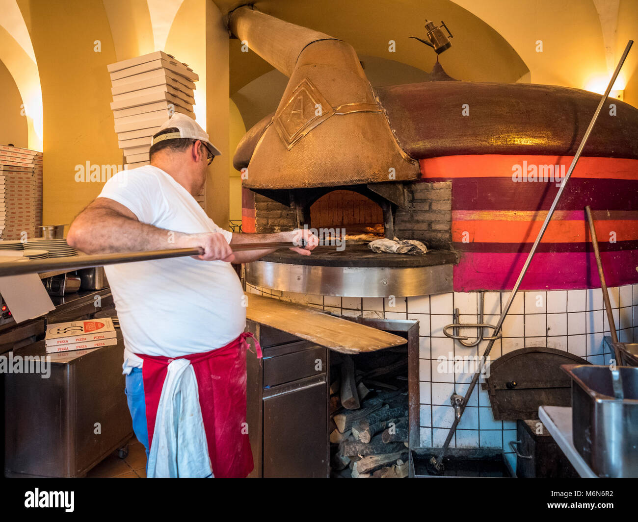 Pizzaiolo lavora con un tradizionale forno a legna Foto Stock