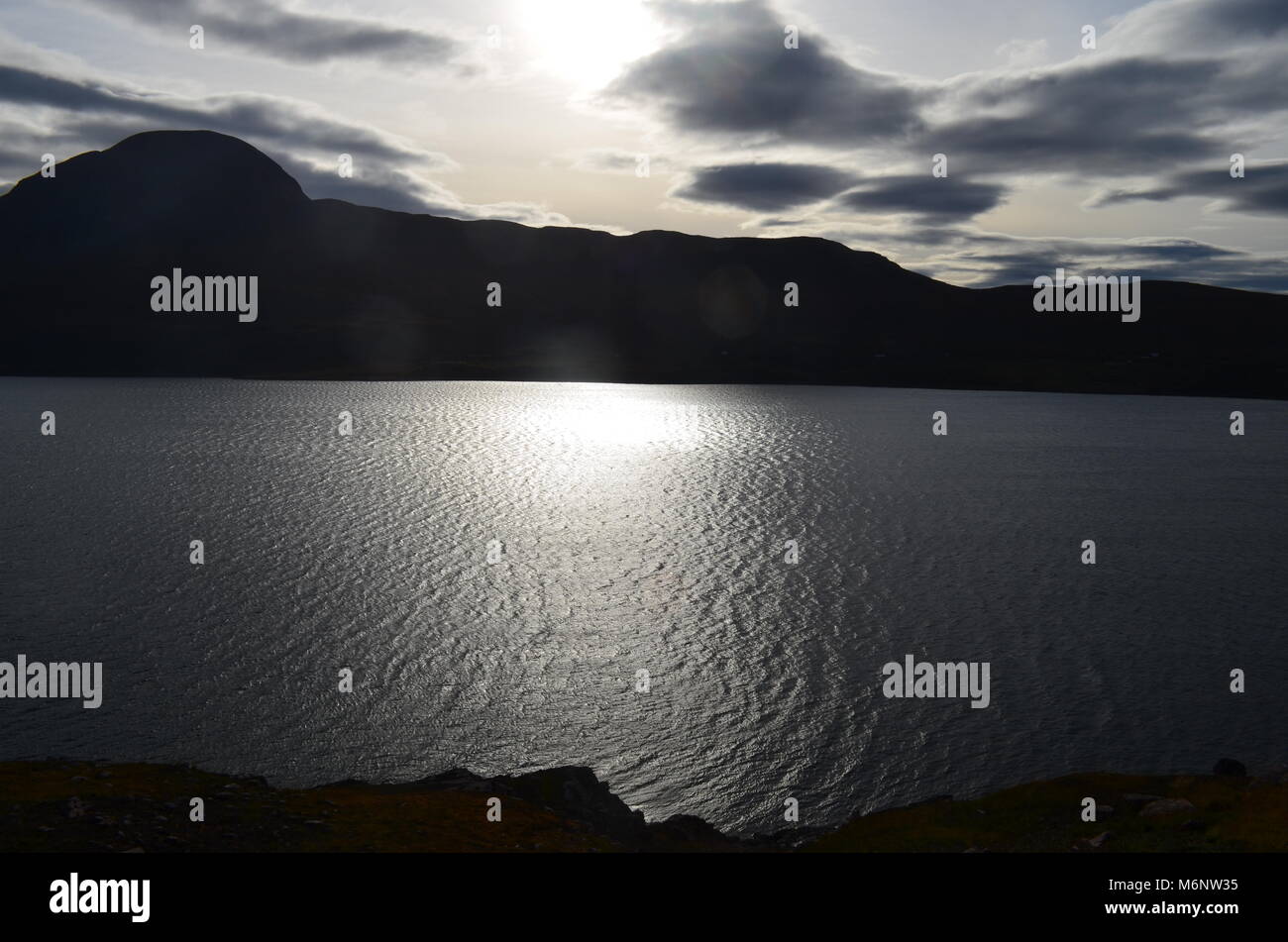 Sun riflettendo sul piccolo Loch Ginestra Foto Stock