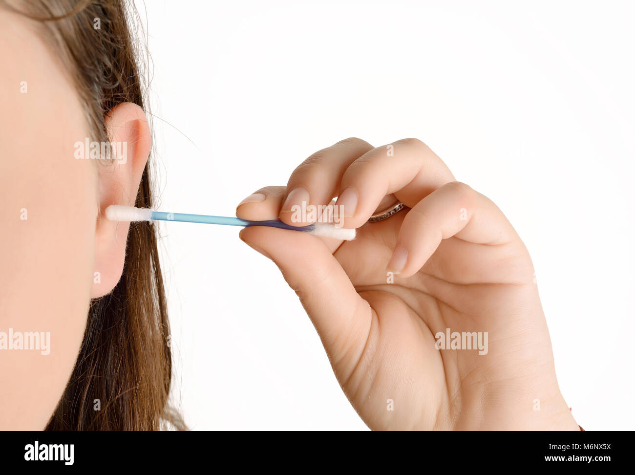 Close up della donna la pulizia il suo orecchio con un bastoncino di cotone. Isolato su sfondo bianco Foto Stock