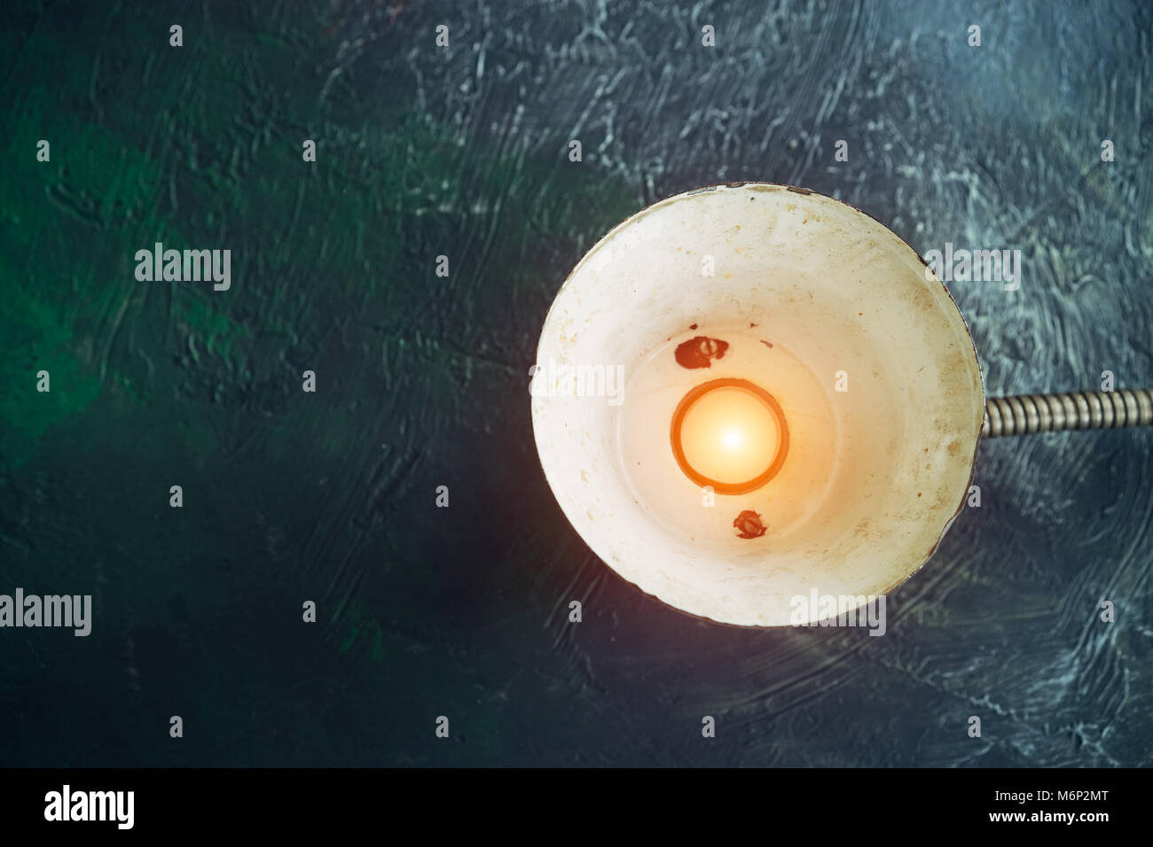 Vintage lampada in metallo con una candela che brucia, su un verde di sfondo astratto, il concetto della terra ora Foto Stock